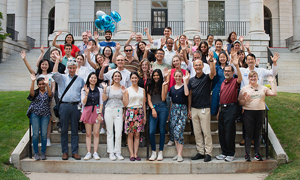 A couple dozen unit members pose together in front of a building. A couple dozen unit members pose together in front of a building.